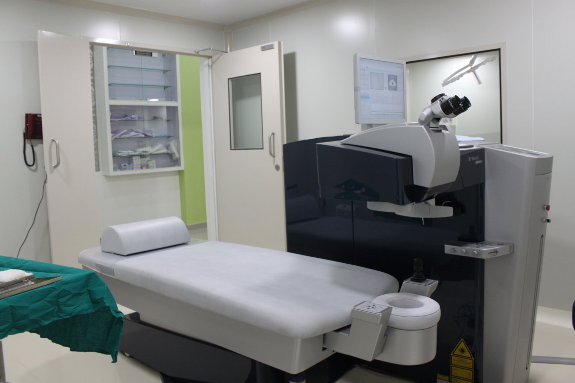 Refractive surgery theatre at Insight Institute with the WaveLight LASIK platform, patient bed and a glazed sterile storage cabinet on the wall